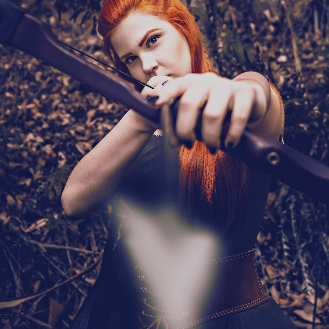 red haired elven looking person holding an archery bow in forest