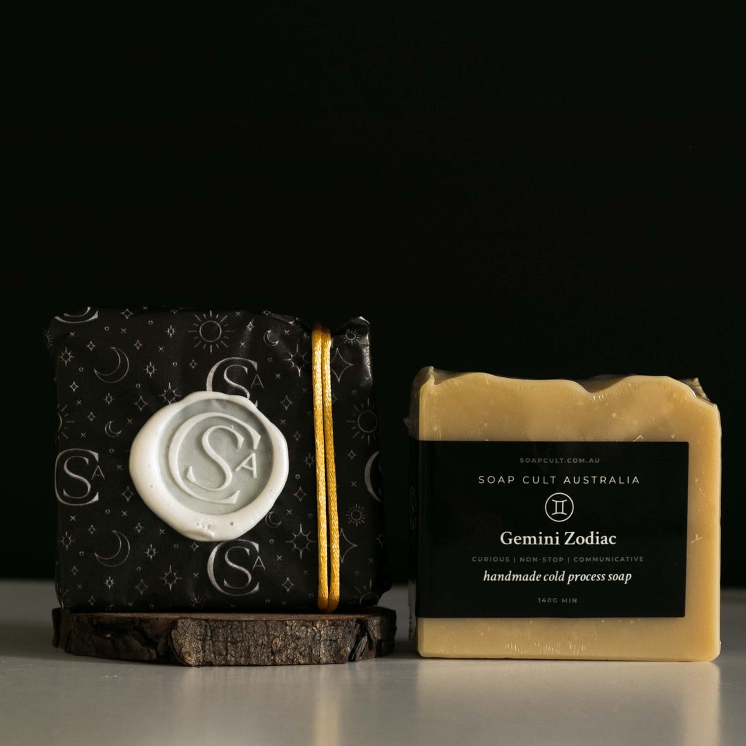 gemini zodiac soap wrapped beside a gift wrapped version with white table and black background
