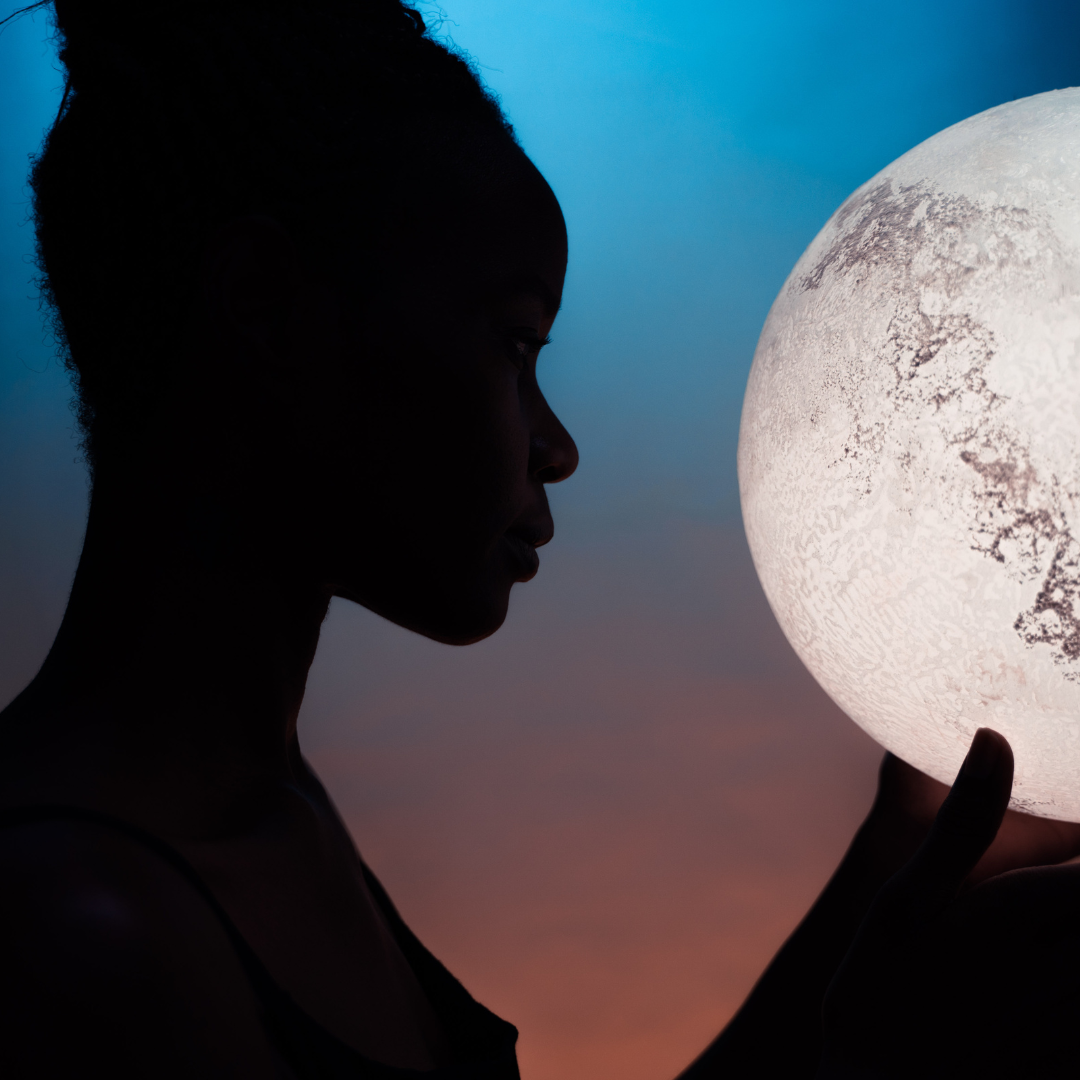 close up profile shot of woman holding a moon